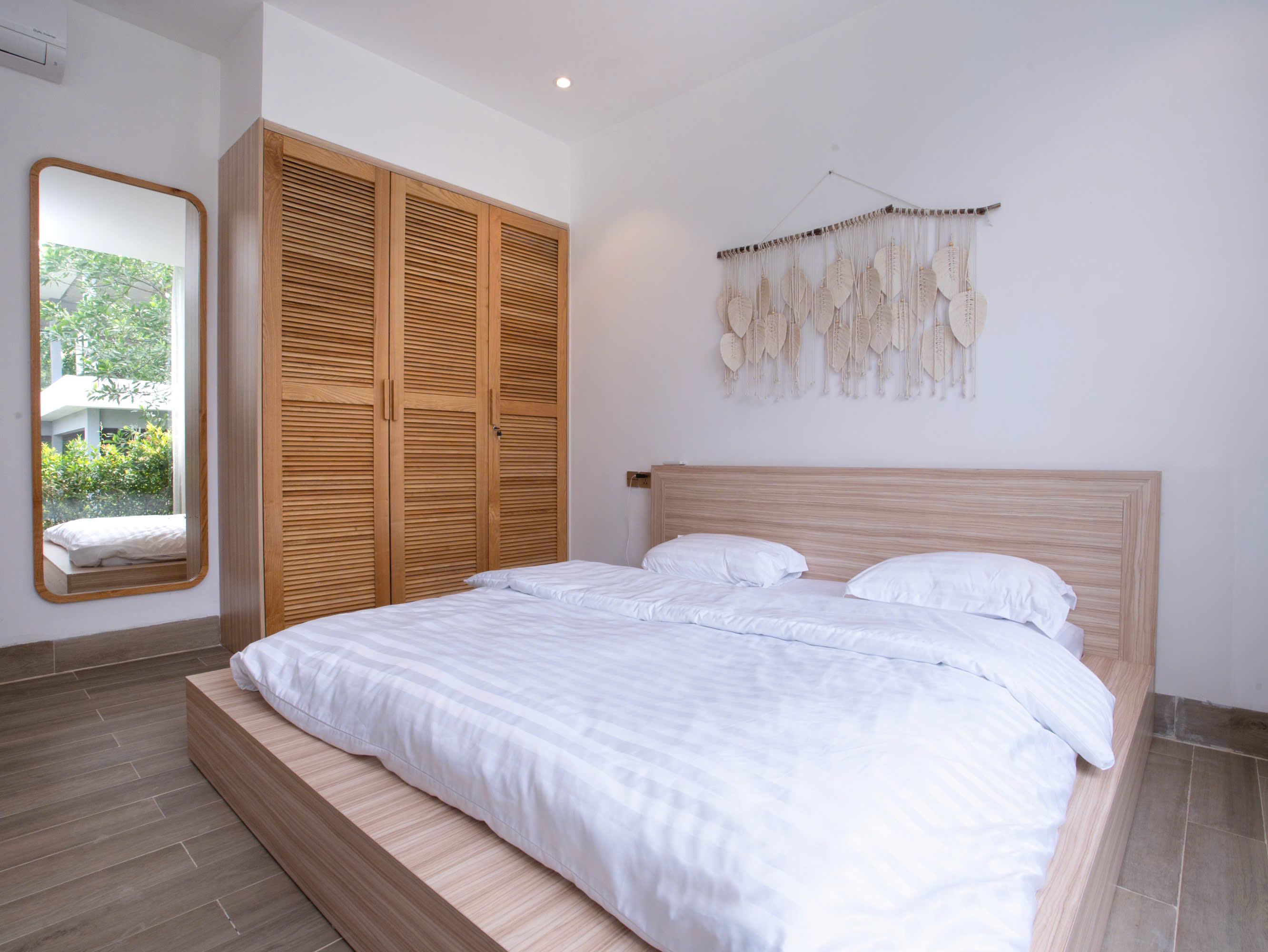 Phòng ngủ master với cửa sổ kính lớn của CHE GARDEN VILLA